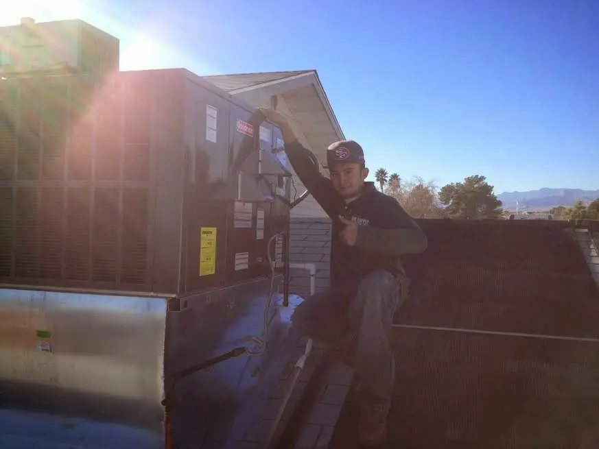 HVAC technician performing Boiler Repair on a rooftop unit in Tysons